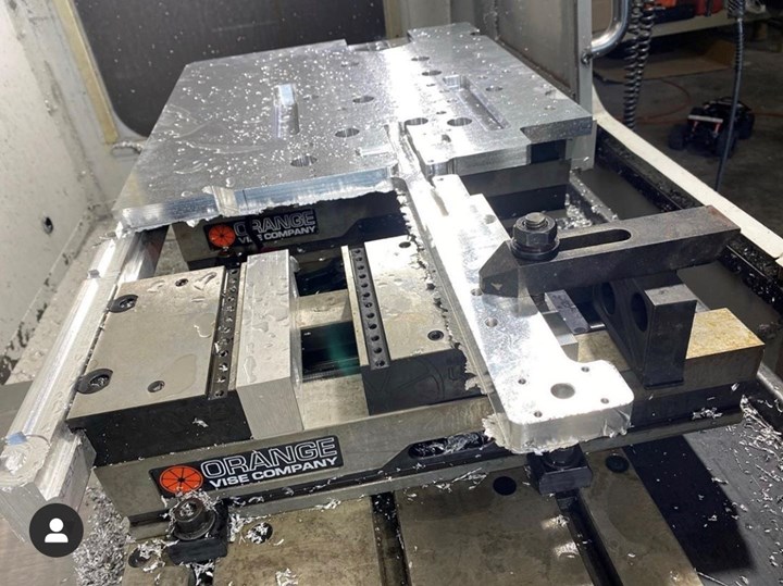 Aluminum plate clamped in a vise inside a machine tool
